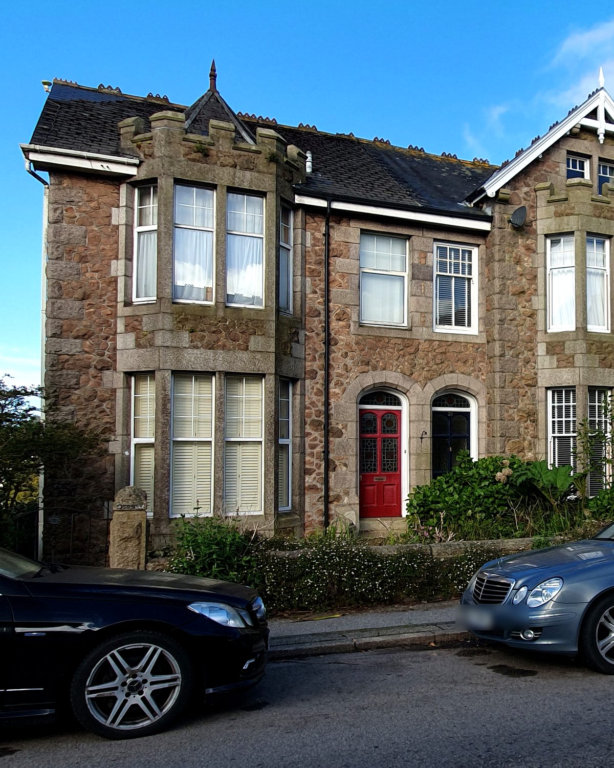 A street of traditional stone villas with bay windows