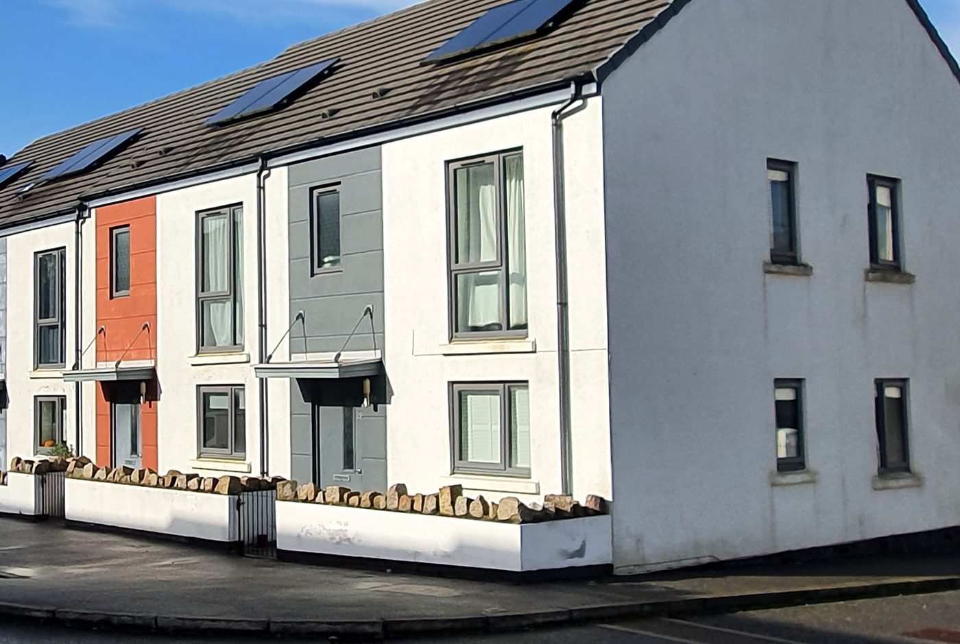 A terrace of newly built homes with solar panels and porch canopies